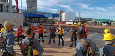 Grupo de trabalhadores da Padilha Andaimes reunido em um pátio industrial.